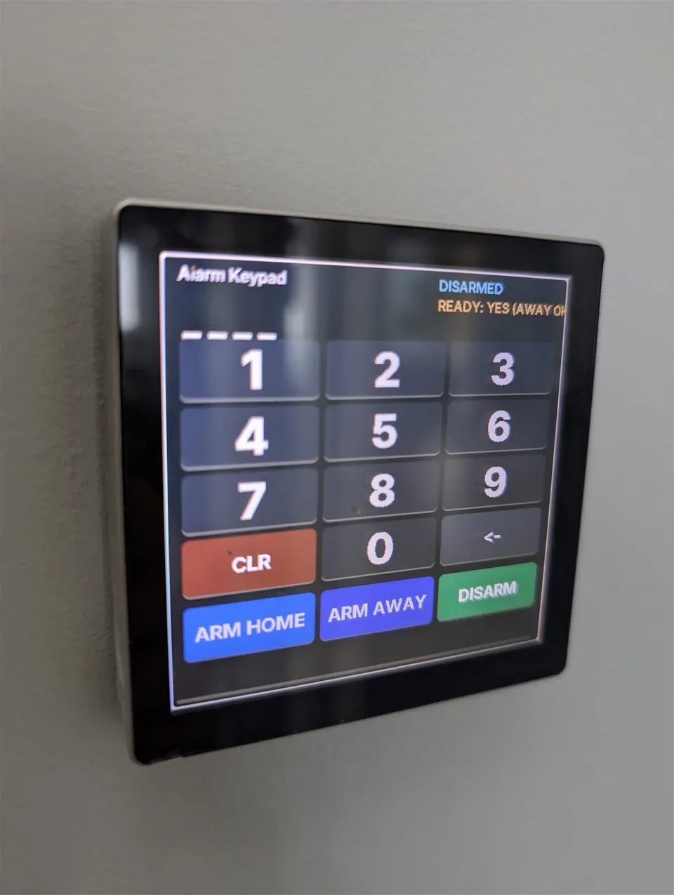 Alarmo touch keypad running the 480alarmokeypad config, wall-mounted and showing live armed state