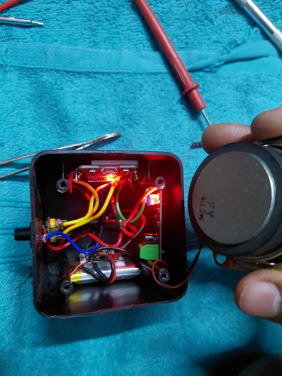 Side view of the assembled device showing the speaker and enclosure.