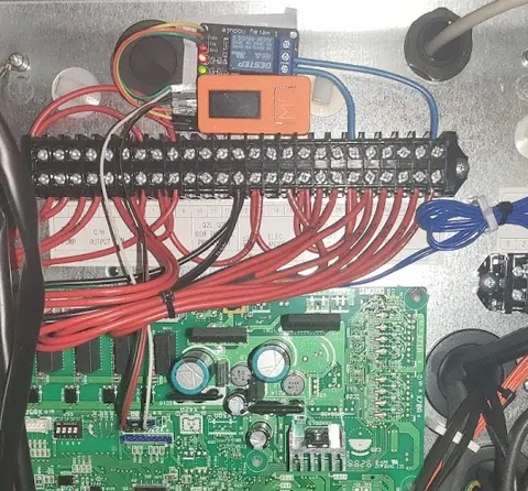 Completed installation with the ESP32 mounted inside the heat pump cabinet next to the main PCB